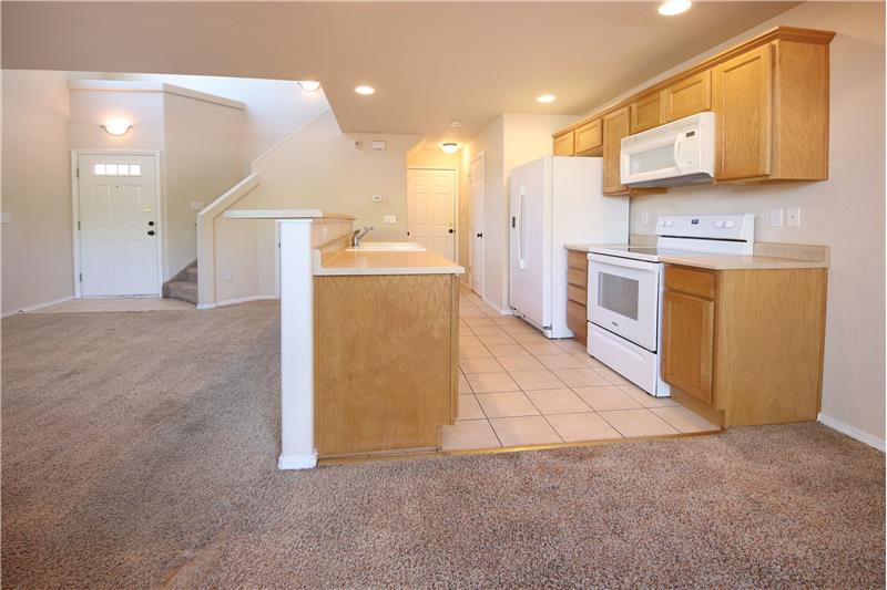 Kitchen with tile floor, counter bar, cabinet pantry, and cabinets with laminate counters