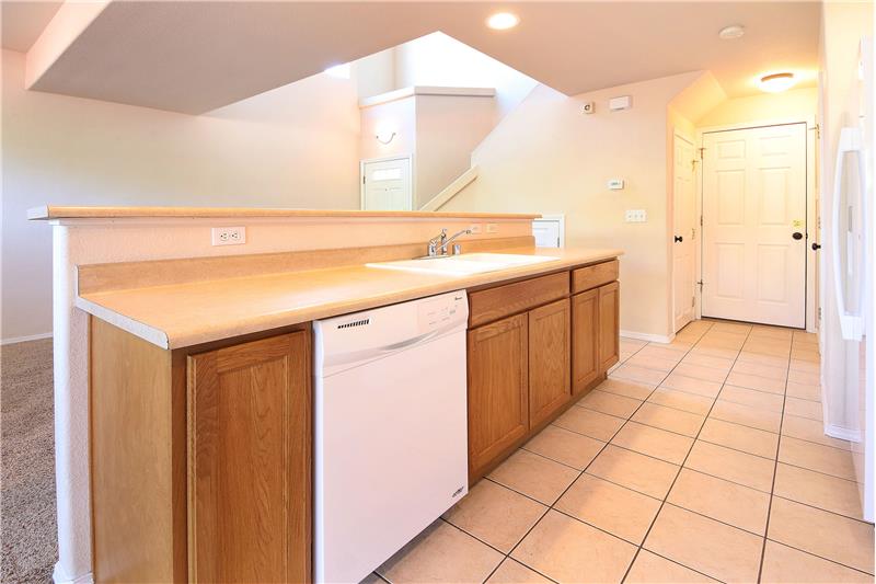 The Kitchen has a counter bar, cabinets with laminate counters, and double sink