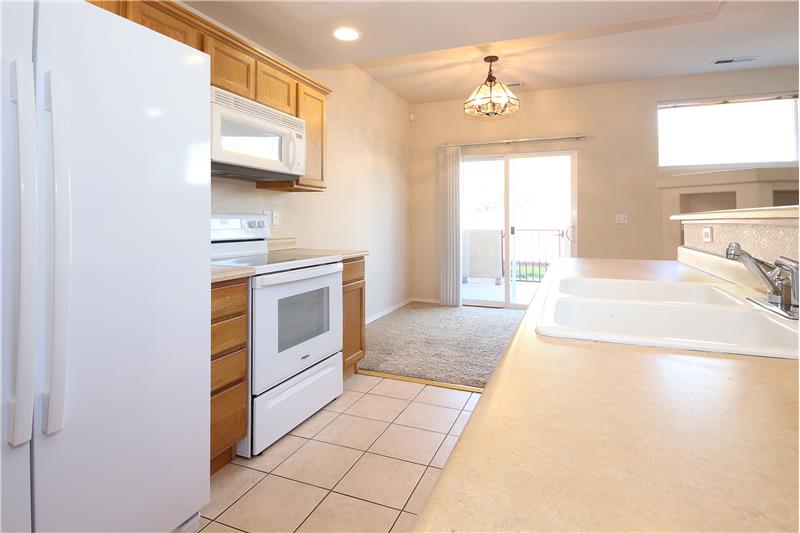 The Kitchen flows into the walk-out Dining Area with slider to a walled patio