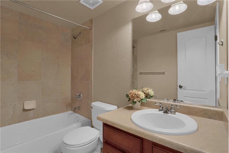 Full bathroom with tile surround and tile flooring