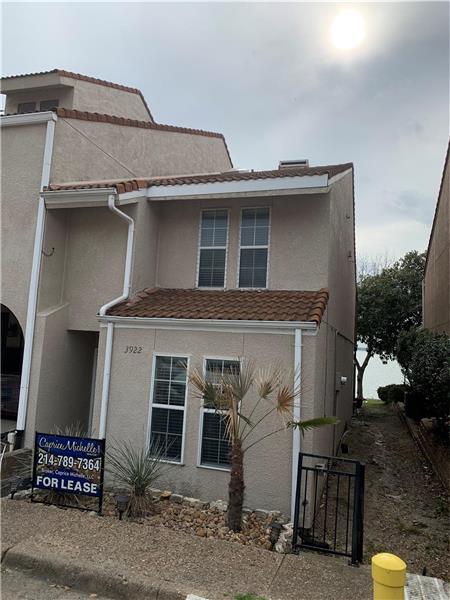 View of front of home featuring stucco siding and a tile roof. 2 Uncovered Parking Spaces.