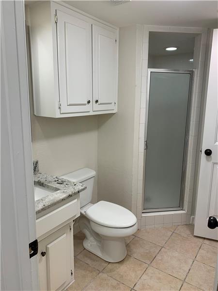 Downstairs Full bathroom with vanity and a shower stall