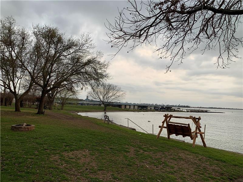 Dock with a water view, a yard, and a fire pit