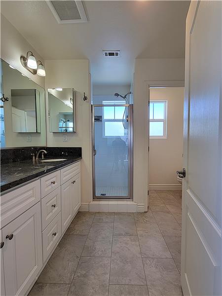 Primary Bathroom with tile floor, private water closet and floor-to-ceiling cabinet (out of view).