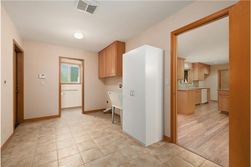 Large mud-room and utility room from Garage to the left provides quick access to the 1/2 bath and the kitchen.
