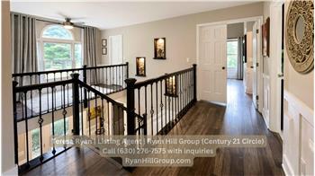 The wide upper hallway carries the custom wainscoting and engineered wood flooring from the main level.