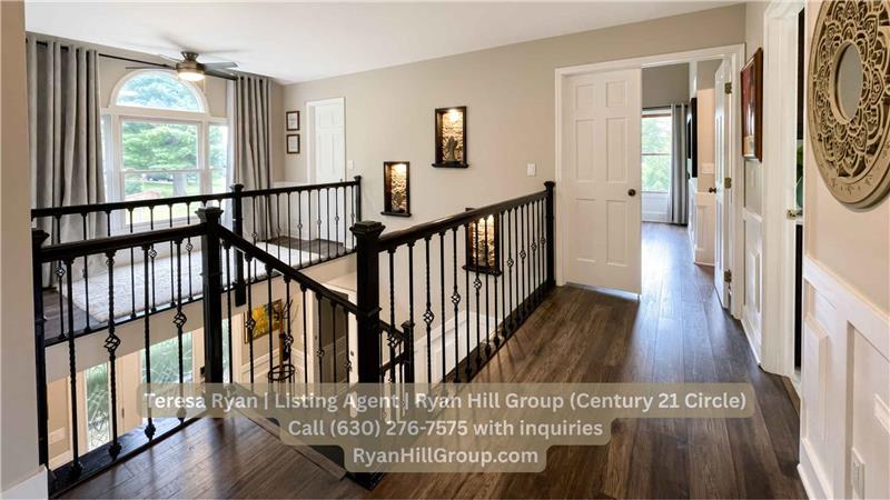 The wide upper hallway carries the custom wainscoting and engineered wood flooring from the main level.