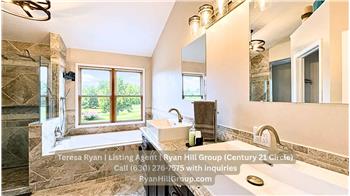 14-by-12-foot primary bathroom, two vessel sinks sit above custom cabinetry and granite countertops