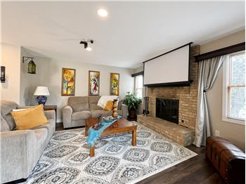 Family room with brick fireplace with gas logs and a traditional mantel anchors the room