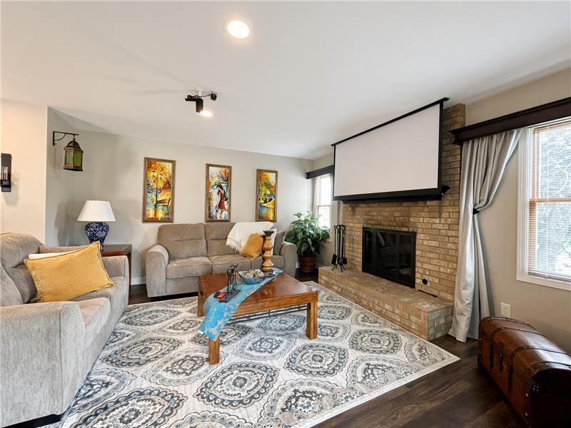 Family room with brick fireplace with gas logs and a traditional mantel anchors the room