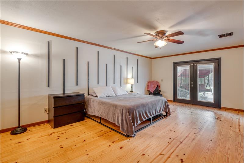 Extra large primary bedroom with French door access to back deck sitting area