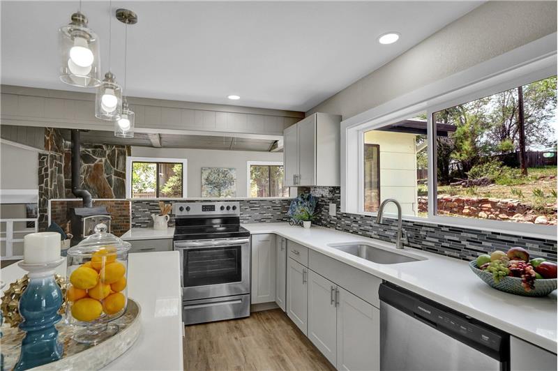 New cabinets with quartz countertops and tile backsplash