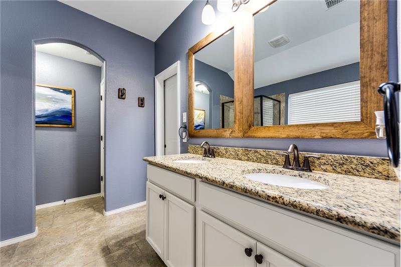 Double vanity with granite counters, and framed mirrors