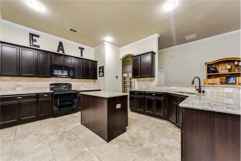 Enormous kitchen with island, granite, upgraded faucet and complemented with hardware