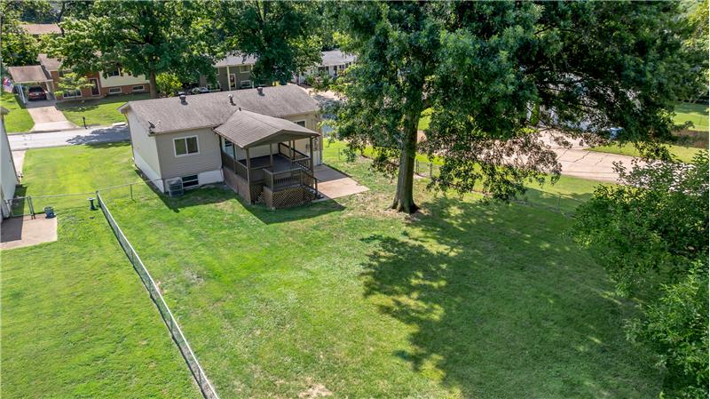 Big Fenced back yard with a covered deck.