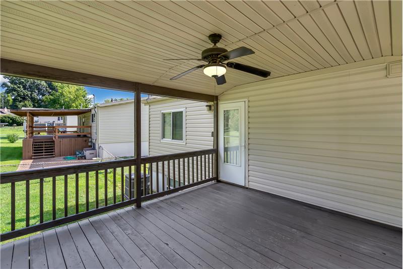 Large covered deck has a ceiling fan.