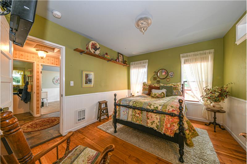 Primary bedroom has walk in closet, wainscotting on the walls, and beautiful original fir flooring.