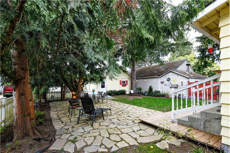 Fully fenced yard with flagstone patio and wonderful shade trees for hot days.