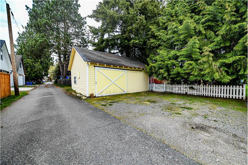 Detached garage with sliding barn door and alley access.