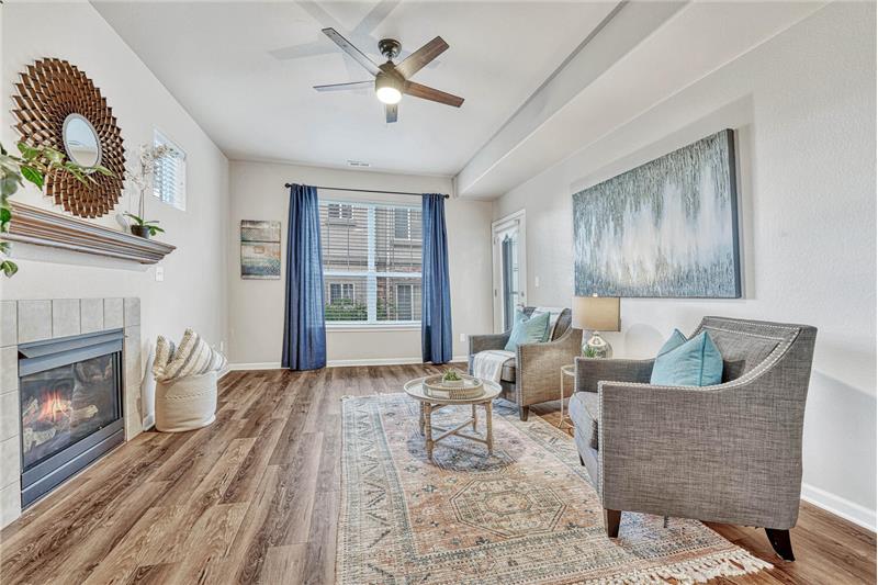 The Living Room features gorgeous flooring, a gas log fireplace, and a new ceiling fan