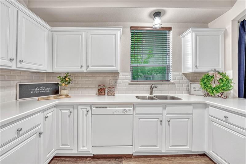 Bright kitchen with white cabinetry and a tile backsplash