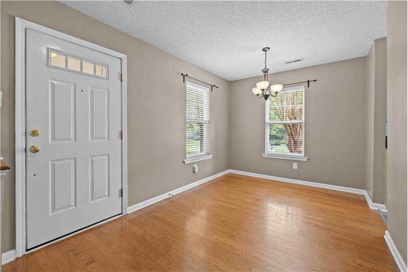 Entrance to the home and dining room with hardwood floors