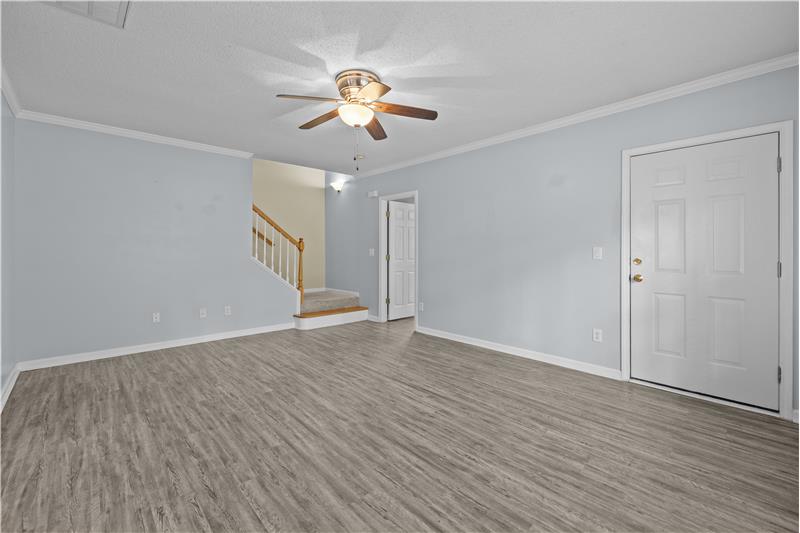 Living room features neutral paint, ceiling fan