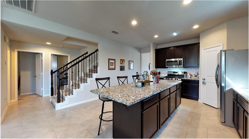 The kitchen features granite counters, subway tile backsplash, and stainless steel appliances.