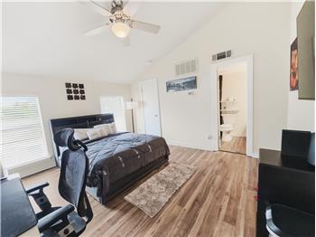 Primary bedroom with walk in closet, vaulted ceilings.
