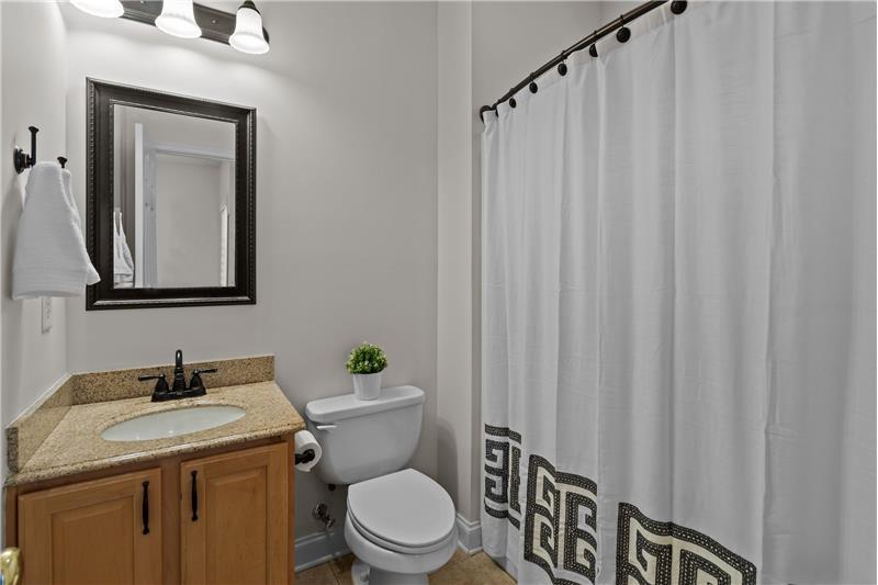 En-suite bathroom with granite vanity counter, tile flooring, tub/shower combination