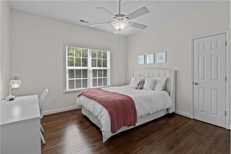 One of four additional bedrooms on second floor of home, all with hardwood flooring and ceiling fans with lights