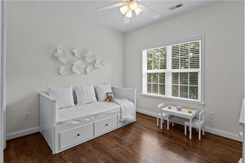 One of four additional bedrooms on second floor of home, all with hardwood flooring and ceiling fans with lights