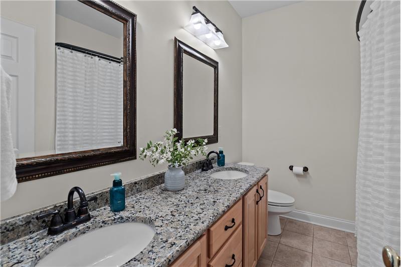 Full bathroom on second floor with double sink vanity, granite counter, updated mirrors and lights, tile flooring, tub/shower