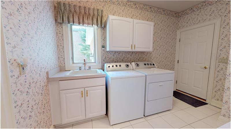 First floor laundry room includes the washer and dryer and has lots of cabinets for storage!