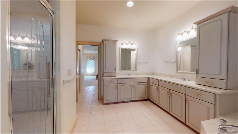 Master bath with double vanities, jacuzzi tub, and tiled shower!