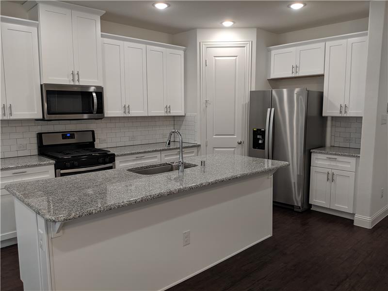 White cabinets, stainless appliances, quartz counters
