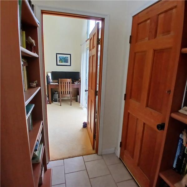 Hall area off living room with bedrooms on either side and an exterior door