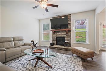 Stacked stone gas log fireplace featured in living room