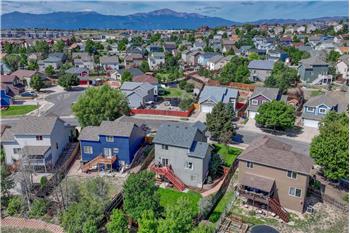 Aerial rear view of home, backyard, and neighborhood with mountain views in the front.
