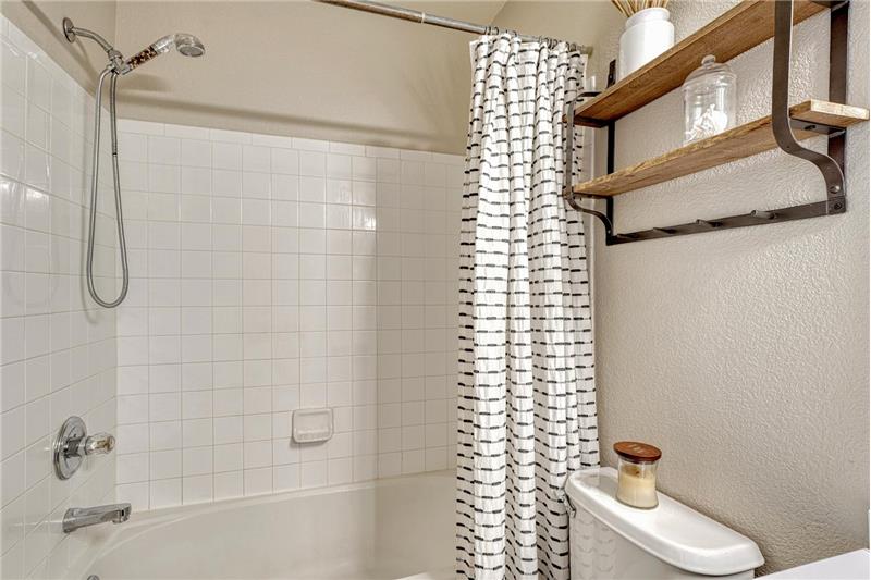 The Primary Bathroom has a dual sink vanity and tiled soaking tub/shower.