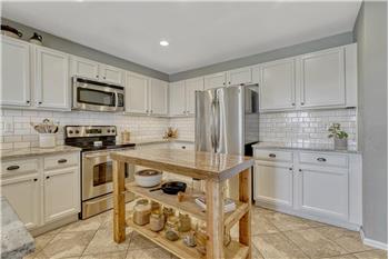 The stylish Kitchen offers white cabinets, granite countertops, subway tile backsplash, pantry, & water filtration system.