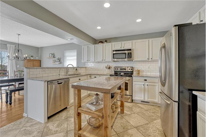 Stainless steel appliances incl a range oven, microwave, dishwasher, & French door refrigerator.
