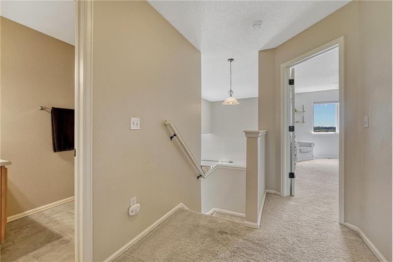 Upper level hallway with entrance to the upper level bathroom and Primary Bedroom.