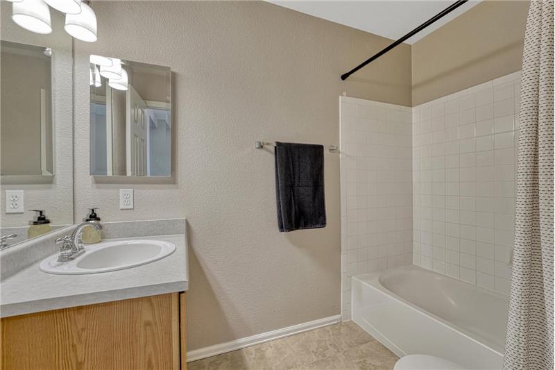 Upper Level Full Bathroom with vanity, medicine cabinet, and tiled tub/shower.