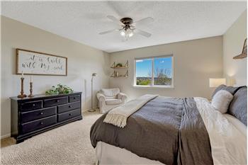 The spacious Primary Bedroom is a private retreat with lighted ceiling fan and sitting area.