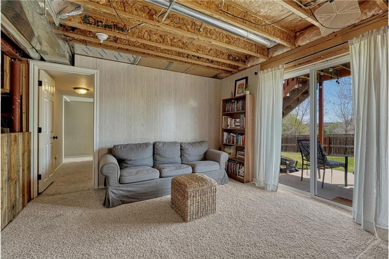 Unfinished basement Family Room with slider to the backyard patio.