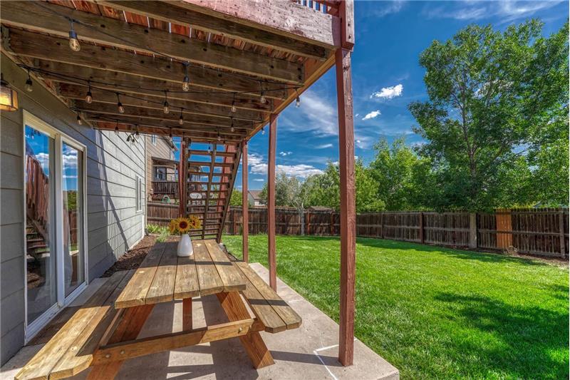 Covered patio overlooking the well manicured fenced backyard.