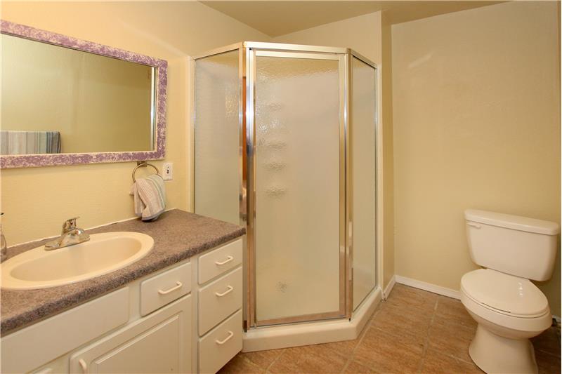 Large 3/4 bath with tile flooring in basement