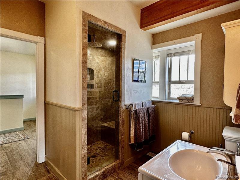 Primary bathroom has steam shower; note door to foyer