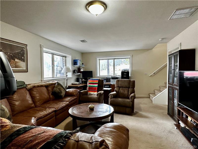 Family room on lower level showing stairs at rear